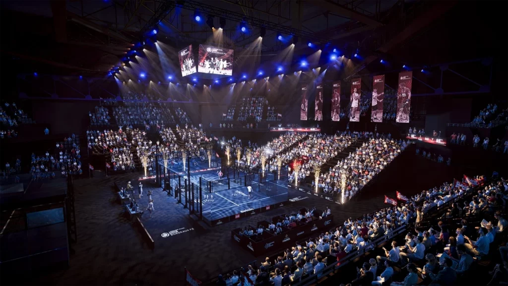 Une foule nombreuse remplit une arène, éclairée par des lumières bleues et blanches, et assiste à un match d'arts martiaux mixtes à l'intérieur d'une cage centrale. Plusieurs écrans diffusent l'événement au-dessus du ring et des bannières sont accrochées autour de la salle.